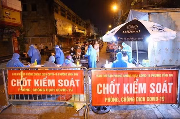 Nhân viên y tế quận Hai Bà Trưng (Hà Nội) tổ chức 4 dây chuyền lấy mẫu xét nghiệm COVID-19 cho người dân phố Mạc Thị Bưởi, phường Vĩnh Tuy ngay trong đêm. Ảnh: Hoàng Hiếu/TTXVN