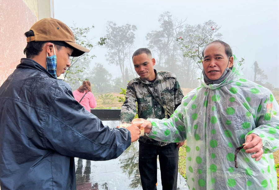 Đồng bào vùng cao chúc nhau ngày tết bằng ly rượu tà vạc ngay không gian Cửa khẩu quốc tế Nam Giang - Đắc Tà Oọc. Ảnh: ALĂNG NGƯỚC