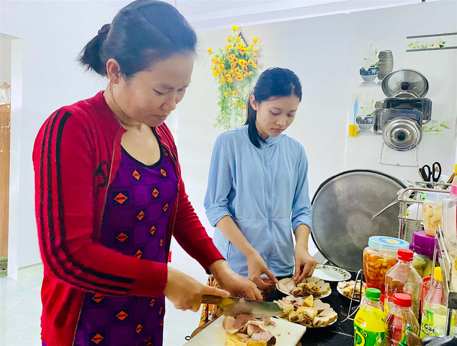 Chị Đặng Thị Mỹ Hằng (thôn 4, xã Thành An, thị xã An Khê) cùng con gái chuẩn bị mâm cơm cúng đưa ông bà trong chiều mùng 3 Tết. Ảnh: Mộc Trà