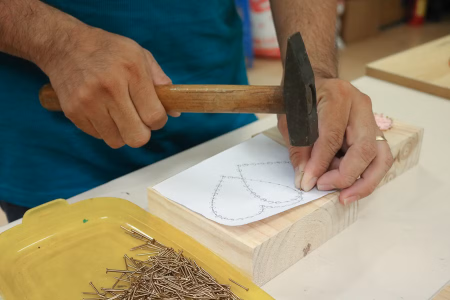 Giai đoạn thiết kế mẫu đóng vai trò quan trọng bậc nhất trong việc tạo hình sản phẩm. Sau khi phác thảo, anh Thành đặt trên khung gỗ để lấy dấu đinh dựa trên bản thiết kế. Ảnh: Ngọc Long