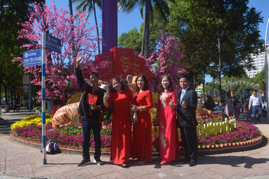  Người dân du xuân, chụp ảnh lưu niệm tại khu vực đường hoa TP. Buôn Ma Thuột. Ảnh: L.Anh