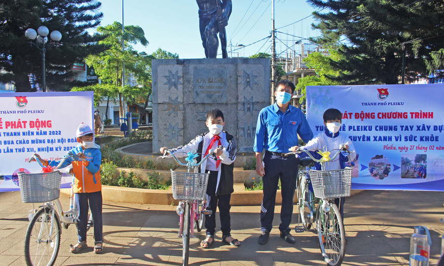 Anh Thái Giang Nam (thứ 2 từ phải qua)-Phó Bí thư Thành Đoàn Pleiku tặng xe đạp cho 3 học sinh khó khăn. Ảnh: Phan Lài