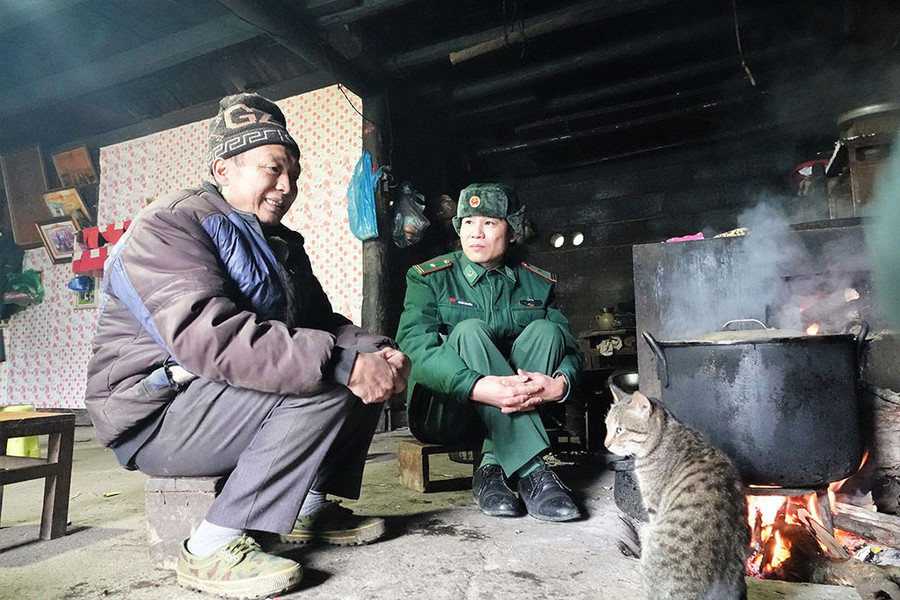 Thiếu tá Nguyễn Văn Chủng (phải), Chính trị viên phó Đồn biên phòng Xín Cái, xuống thăm hỏi, động viên các hộ dân vượt qua giá rét, ổn định cuộc sống thường nhật. Ảnh: Mai Thanh Hải