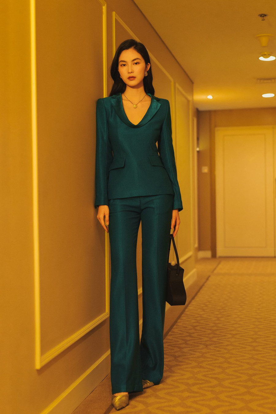 Suit xanh đen trên chất vải wool pha metallic được dựng phom hoàn hảo giúp tôn dáng, kết hợp cùng kiểu cổ đổ phối lụa mềm mại tạo nên nét riêng.