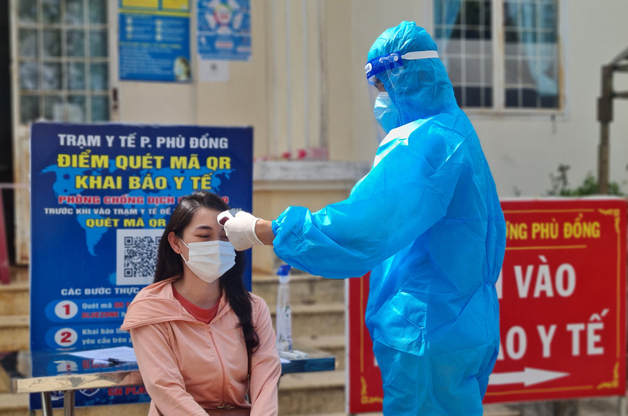 Kiểm tra thân nhiệt người dân đến khai báo y tế tại trạm y tế phường Phù Đổng (TP. Pleiku)