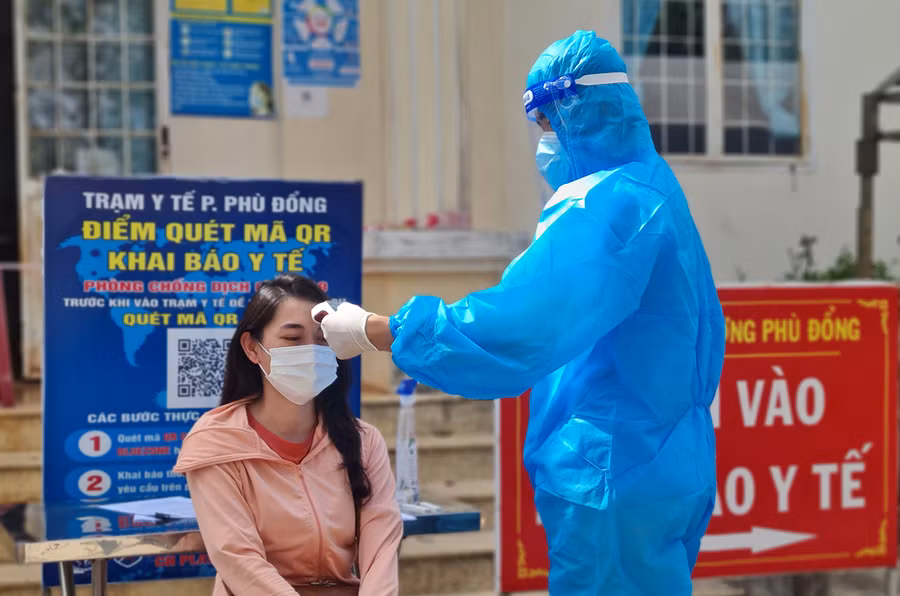 Kiểm tra thân nhiệt người dân đến khai báo y tế tại trạm y tế phường Phù Đổng (TP. Pleiku)