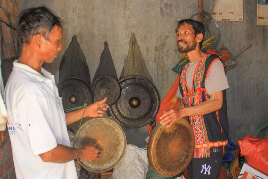 Đội trưởng đội chiêng A Kyunh (phải) cùng đội phó A Phái trao đổi, tập luyện về chiêng. Ảnh: HT