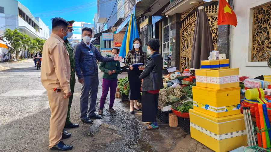 Ảnh 2: Lực lượng chức năng phường Phù Đổng (TP. Pleiku) nhắc nhở hộ kinh doanh tại khu vực trước chợ Phù Đổng không lấn chiếm lòng đường, vỉa hè.