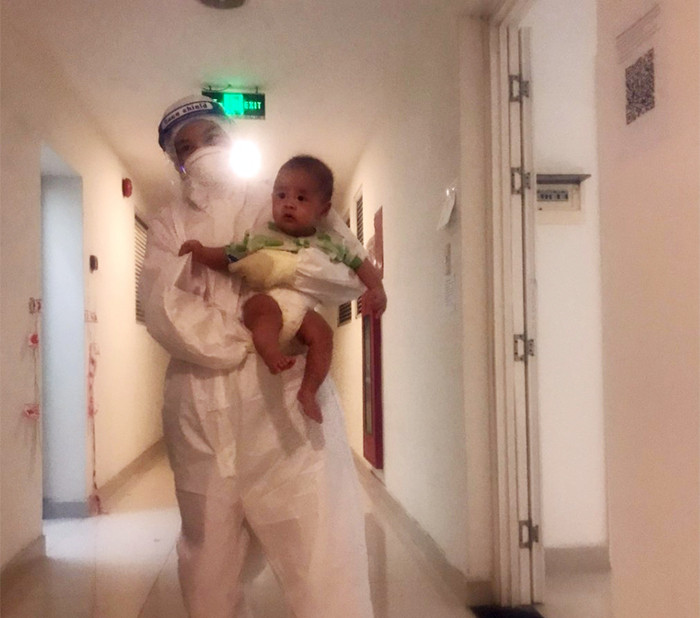 Em bé 3 tháng tuổi được điều dưỡng chăm sóc khi bà ngoại trở nặng tại bệnh viện dã chiến.