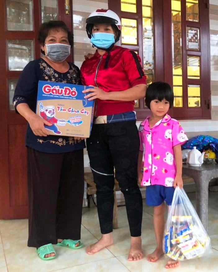 Bà Nguyệt (trái) hỗ trợ nhu yếu phẩm và tiền mặt cho một gia đình trẻ gặp khó khăn đột xuất vì chồng bị tai nạn. Ảnh: Đinh Yến