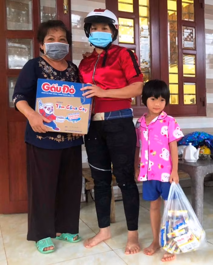Bà Nguyệt (trái) hỗ trợ nhu yếu phẩm và tiền mặt cho một gia đình trẻ gặp khó khăn đột xuất vì chồng bị tai nạn. Ảnh: Đinh Yến