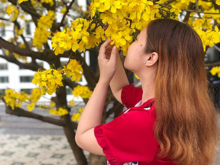 Chị Hương mong gặp được may mắn, an lành khi chụp hình với hoa mai trong dịp đầu năm. Ảnh: NVCC