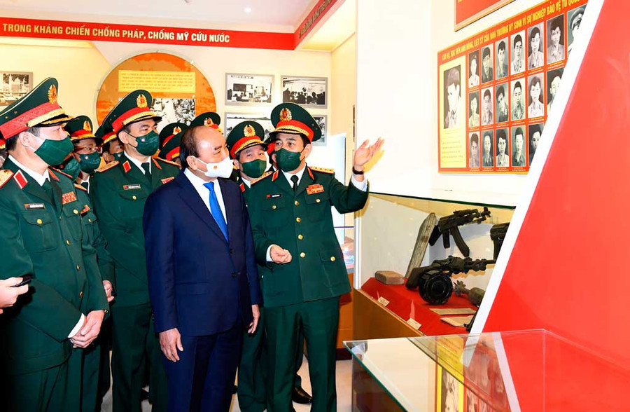 Đại tướng Phan Văn Giang, Ủy viên Bộ Chính trị, Bộ trưởng Bộ Quốc phòng (bìa phải) kể lại gương hy sinh của 22 liệt sĩ - học viên Trường Sĩ quan Chính trị, với Chủ tịch nước Nguyễn Xuân Phúc, trong ngày Chủ tịch nước về thăm và làm việc với Trường Sĩ quan Chính trị (ngày 19.12.2021). Ảnh: Tuấn Huy