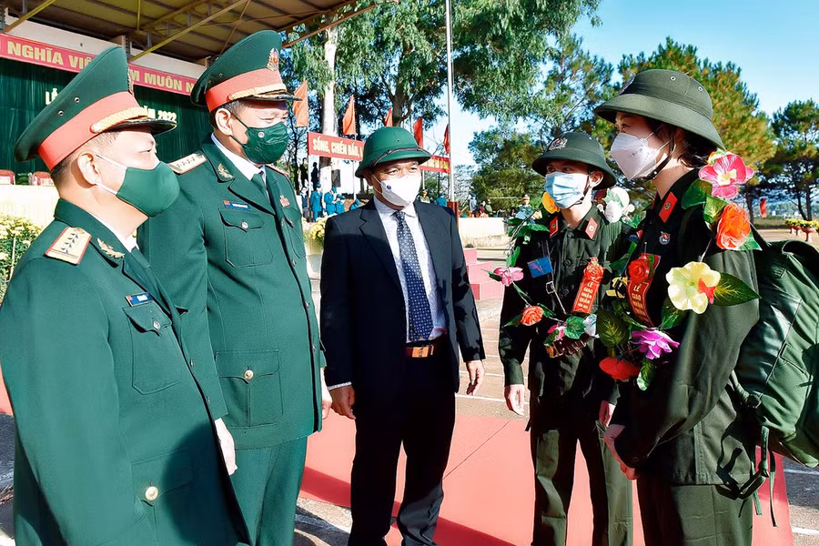 Bí thư Tỉnh ủy Hồ Văn Niên (bìa phải) tặng hoa, động viên các thanh niên lên đường nhập ngũ. Ảnh: Quang Tấn 