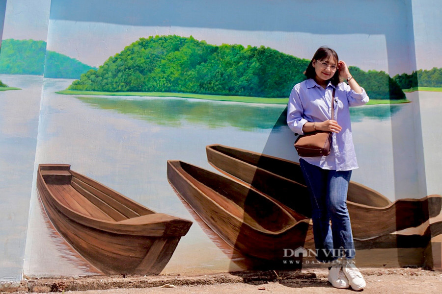 Một bạn trẻ chụp hình tại con đường bích hoạ Buôn Tơng Jú. Ảnh: TT Một bạn trẻ chụp hình tại con đường bích hoạ Buôn Tơng Jú. Ảnh: TT