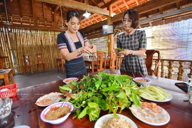 Cô chủ quán người bản xứ xinh đẹp hướng dẫn thực khách cách cuốn một chiếc gỏi lá đúng điệu.