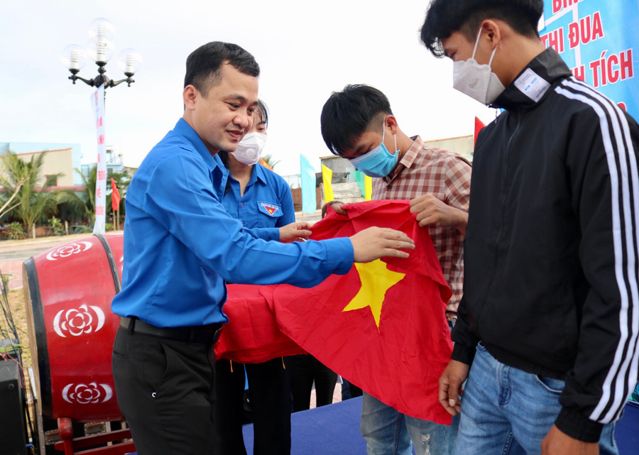 Anh Nguyễn Thành Trung, Phó bí thư Tỉnh đoàn Bình Định, tặng cờ Tổ quốc cho thanh niên xã Mỹ An. Ảnh: Cẩm Vân