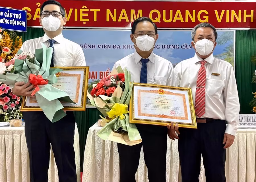 Bác sĩ Nguyễn Hoàng Du (bên trái) nhận bằng khen của Thủ tướng Chính phủ vì có thành tích xuất sắc trong công tác chống dịch Covid-19 năm 2021. Ảnh: Đình Tuyển