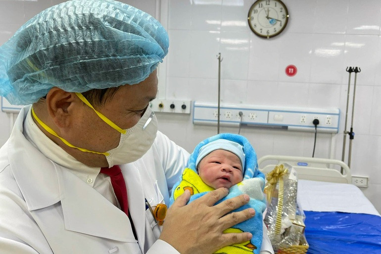 PGS.TS Trần Danh Cường- Giám đốc Bệnh viện Phụ sản Trung ương bế em bé sơ sinh chào đời đúng thời khắc Giao thừa năm Nhâm Dần tại phòng đẻ của Bệnh viện Ảnh: Thái Bình