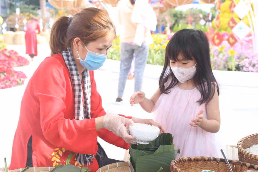  Cho con tham gia nhiều hoạt động ngày tết như gói bánh chưng, bánh tét... Ảnh: T.Đ