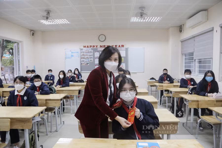 Cô Trịnh Hồng Vân, Hiệu trưởng Trường THCS Thanh Xuân Trung lì xì cho học sinh. Ảnh: Tào Nga