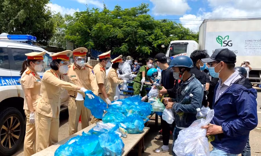 Hội viên Hội Phụ nữ Phòng Cảnh sát Giao thông phối hợp hỗ trợ người dân trở về từ các tỉnh phía Nam để phòng tránh dịch bệnh Covid-19. Ảnh: Nguyễn Hữu