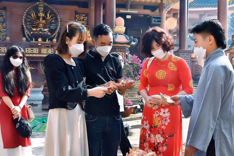 Và tranh thủ xin lộc, cầu bình an cho gia đình. Ảnh: Đức Thụy