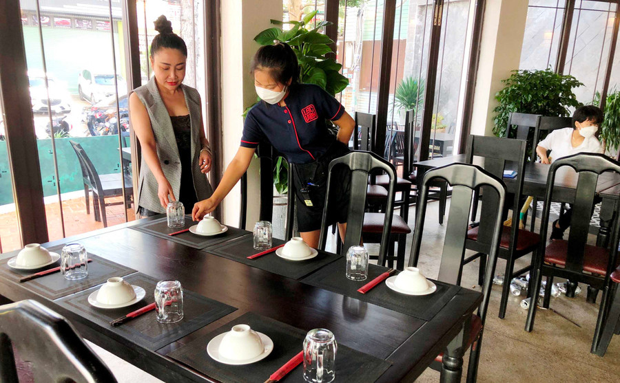 Chủ nhà hàng Lạc Viên hướng dẫn nhân viên em Đào Thị Lương setup bàn cho khách đặt bàn. 