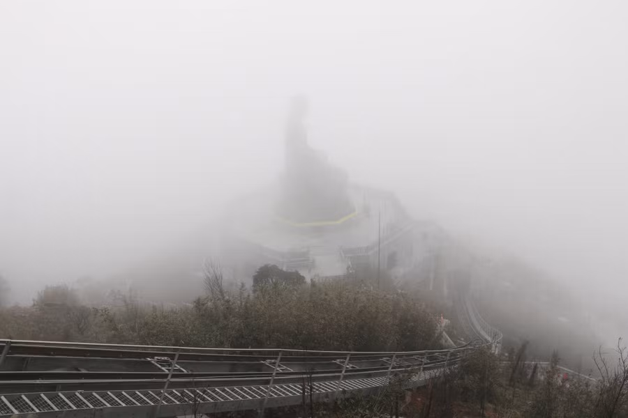 Tượng Phật A Di Đà cao 21,5 m trên đỉnh Fansipan lẫn trong sương mù. Ảnh: Q.T