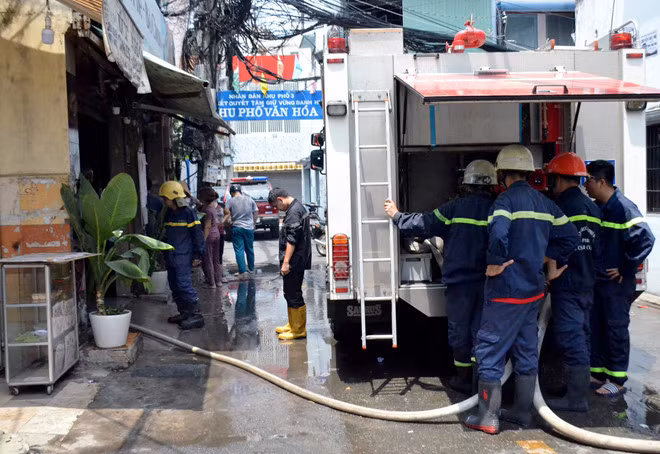 Cảnh sát dập lửa, cứu người thoát khỏi đám cháy.