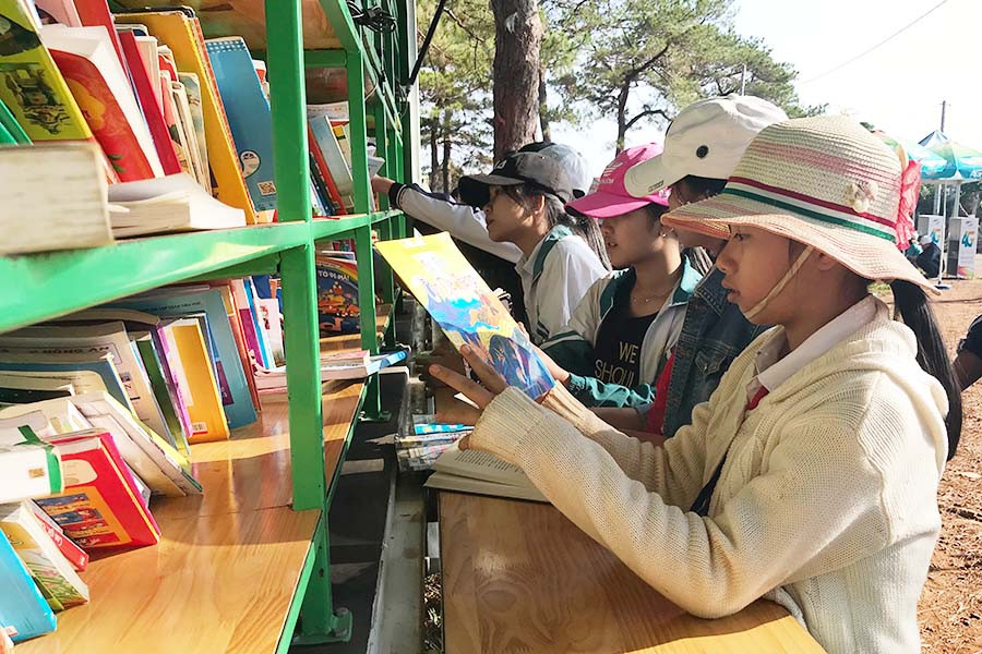 Các em học sinh đọc sách tại xe thư viện lưu động. Ảnh: Phương Vi  Các em học sinh đọc sách tại xe thư viện lưu động. Ảnh: Phương VI