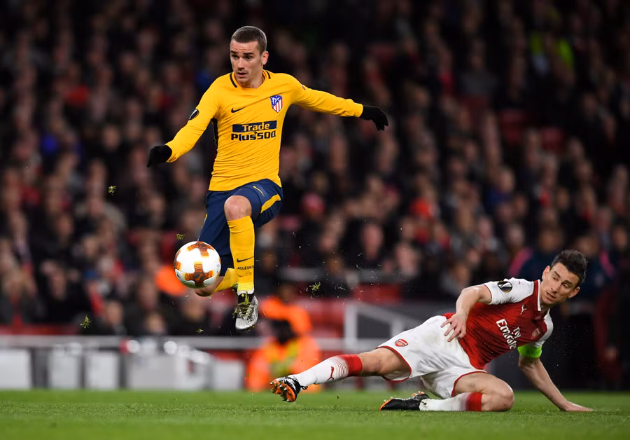  Griezmann vượt qua Koscielny để ghi bàn cân bằng tỉ số. Ảnh: REUTERS