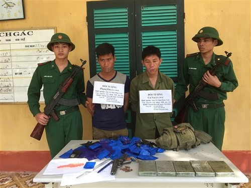  2 đối tượng người Lào bị bắt giữ cùng tang vật (Ảnh: Bộ đội Biên phòng)