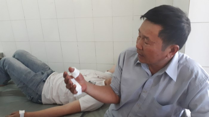 Hai cha con ông Bình bị đạn bắn trúng tay phải nhập viện