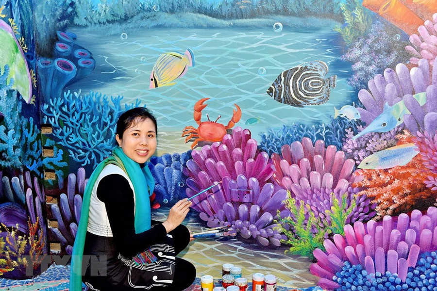 Họa sỹ Nguyễn Thu Thủy bên tác phẩm gắn gốm nghệ thuật Nhà Gương.