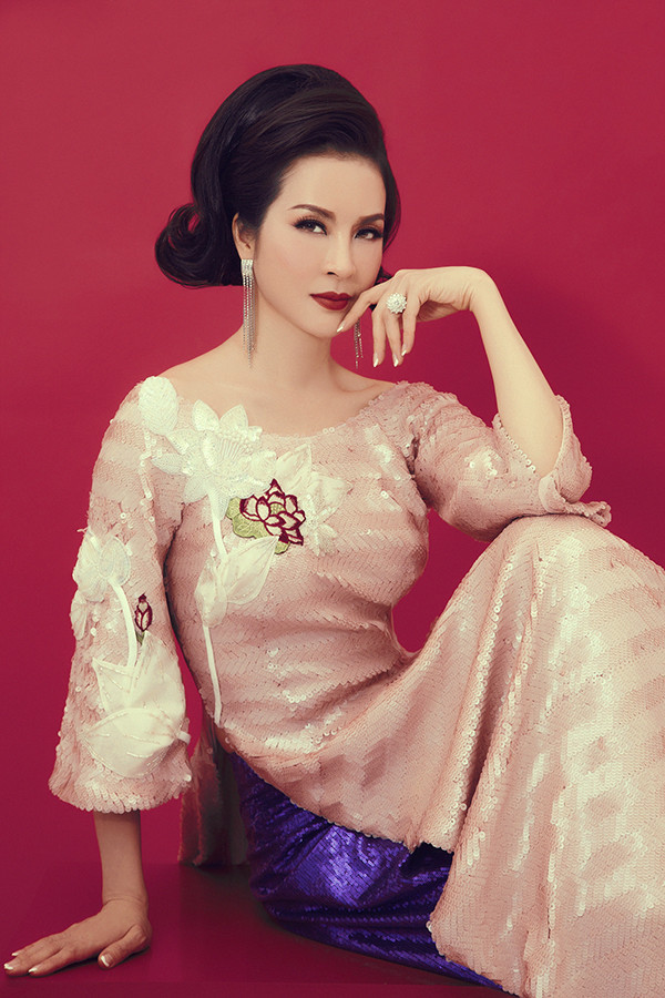 Áo dài thiết kế trên chất liệu vải sequins lấp lánh được nữ MC chọn lựa để giúp mình toả sáng với hình ảnh quý cô cổ điển. Áo dài thiết kế trên chất liệu vải sequins lấp lánh được nữ MC chọn lựa để giúp mình toả sáng với hình ảnh quý cô cổ điển.