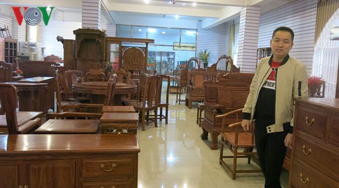 Hoàng Văn Tuyến bên cửa hàng đồ gỗ của mình tại Nam Ninh