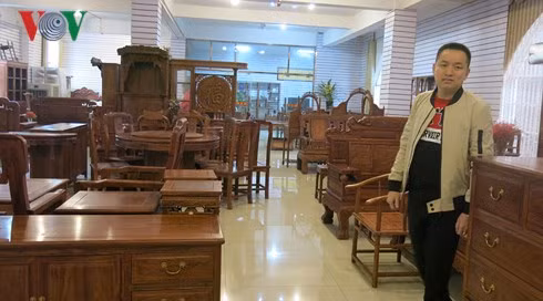 Hoàng Văn Tuyến bên cửa hàng đồ gỗ của mình tại Nam Ninh
