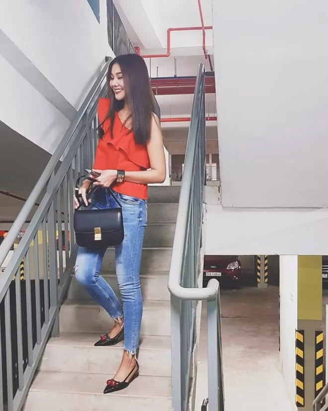  Thanh Hằng biến tấu mới mẻ bộ cánh street style khi ưu ái mẫu áo lệch vai đỏ rực, diện cùng quần jeans rách bụi phủi. Siêu mẫu nhấn nhá trang phục bằng túi Céline và vòng tay Collier de Chien đắt giá của Hermès.