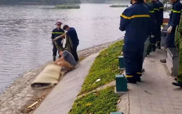 Lực lượng chức năng đưa thi thể nạn nhân lên bờ.