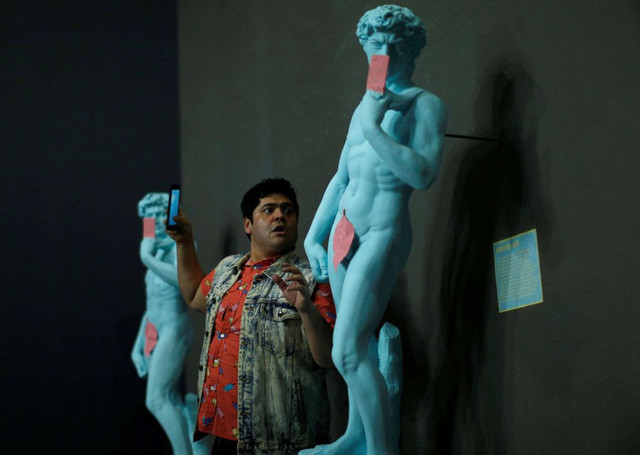 Một du khách nam chụp hình với bức tượng mô phỏng tượng David của Michelangelo