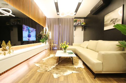 Chủ căn hộ 100m2 ở (Hà Nội) là cặp vợ chồng trẻ yêu thích không gian nhà hiện đại, tinh tế nhưng phải ấm áp nên kiến trúc sư Byzan đã gợi ý gia chủ sử dụng màu gỗ mộc và sự tương phản của gam màu đen trắng làm chủ đạo. Điểm nhấn của phòng khách là diện tường đối diện ghế sofa được xử lý theo mảng khối lớn, tạo sự liền mạch, sang trọng cho không gian.