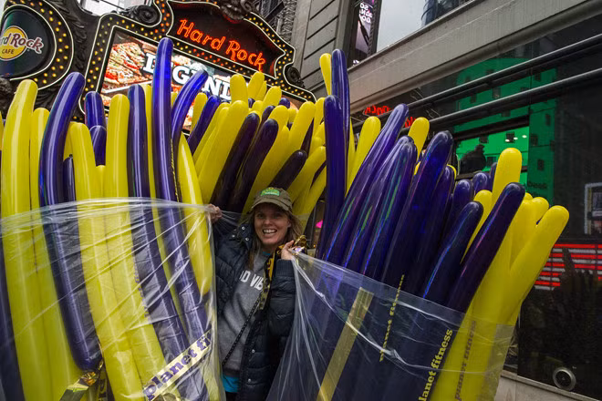 Một công nhân mang bong bóng để phân phát cho các đám đông dự lễ mừng năm mới trong đêm Giao thừa ở Quảng trường Thời đại tại thành phố New York, Mỹ ngày 30.12 - Ảnh: Reuters