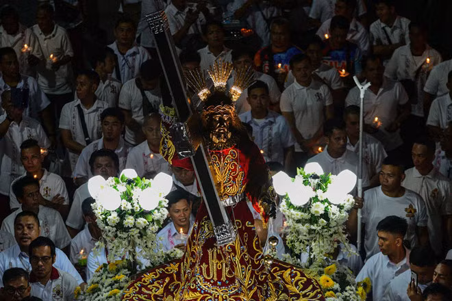 Nhiều tín đồ Công giáo đẩy xe chở tượng Chúa Jesus Đen ở thủ đô Manila, Philippines rạng sáng 31/12. Ngàn hàng tín đồ sẽ tham gia lễ rước tượng này, bắt đầu Đêm Giao thừa và kết thúc vào ngày 9.1 - Ảnh: AFP
