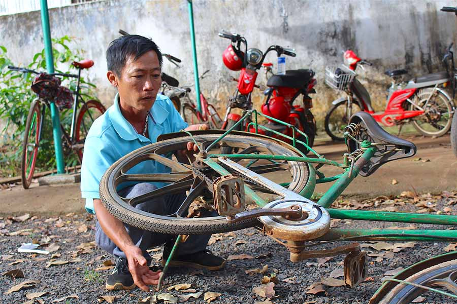  Thầy Đào Thế Hùng sửa chữa lại xe đạp cũ để hỗ trợ học sinh. Ảnh: M.T