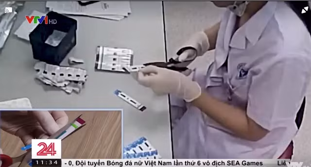 Hình ảnh nhân viên y tế khoa Vi sinh (Bệnh viện Xanh Pôn) cắt đôi bộ test viêm gan B, HIV. Ảnh chụp màn hình VTV24.