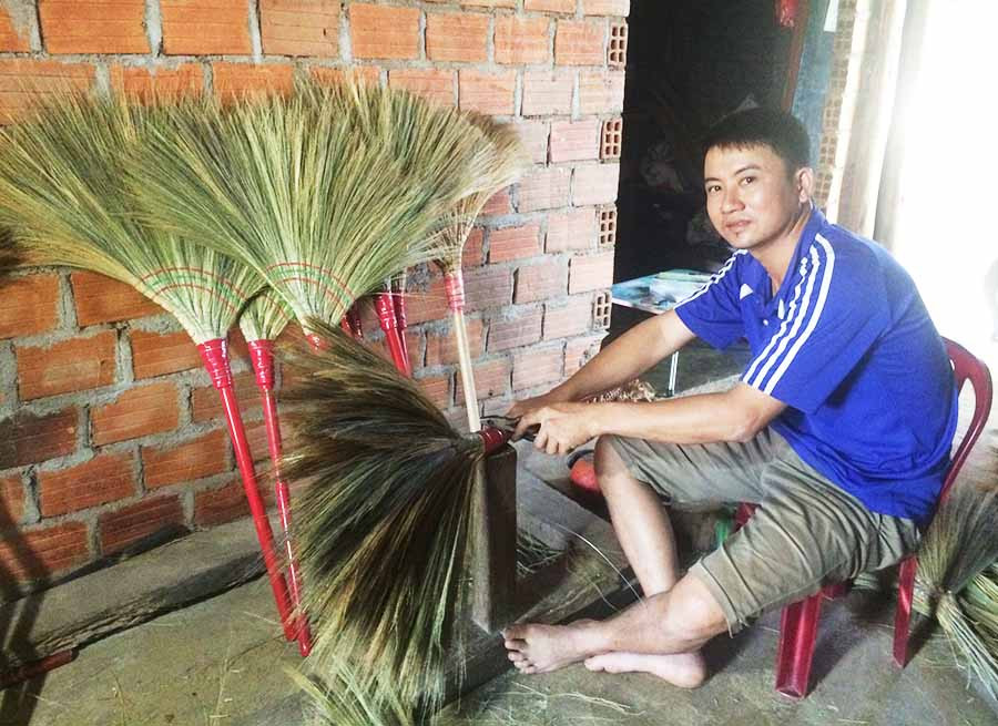  Anh Thắng làm chổi để bán cho khách hàng trong dịp cuối năm. Ảnh: N.H