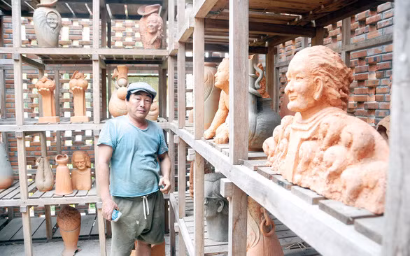 Nghệ nhân Lê Đức Hạ và những sản phẩm đất nung của ông - Ảnh: B.D.