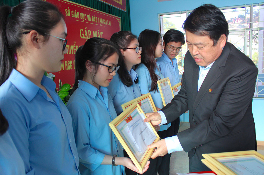Giám đốc Sở GD-ĐT Nguyễn Tư Sơn tặng giấy khen cho các em trong Đội tuyển Ngữ văn. Ảnh: Hồng Thi