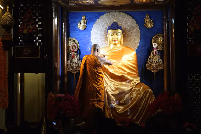 Nghi thức đắp y cho tượng Phật tại chánh điện - Ảnh: Kevin Trần